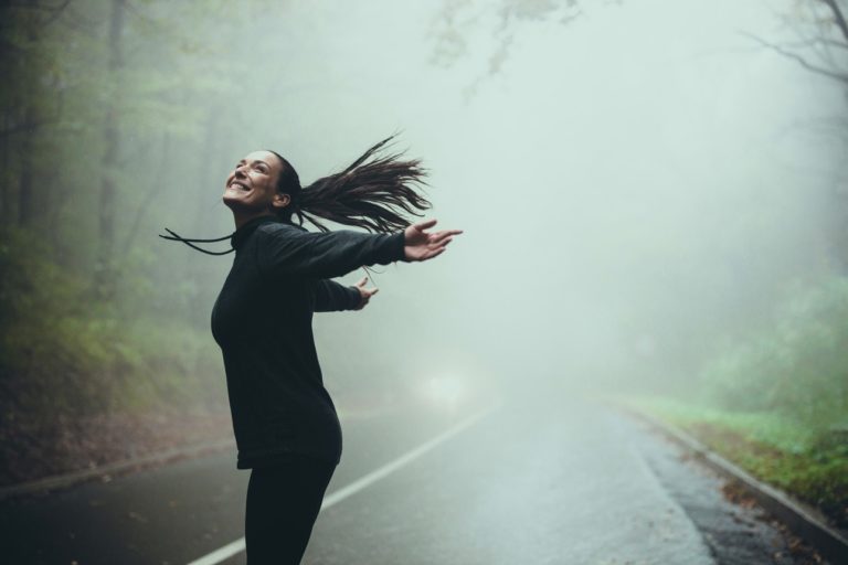 Femme courant dans la brume d'un sous-bois