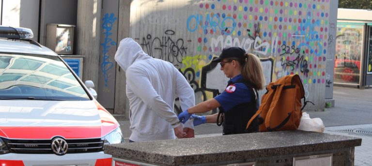 Une policière en train de mennoter un homme vêtu d'un sweet à