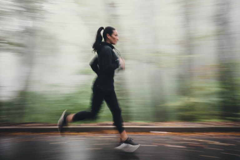 Femme pratiquant la course à pied en forêt par temps de brouillard